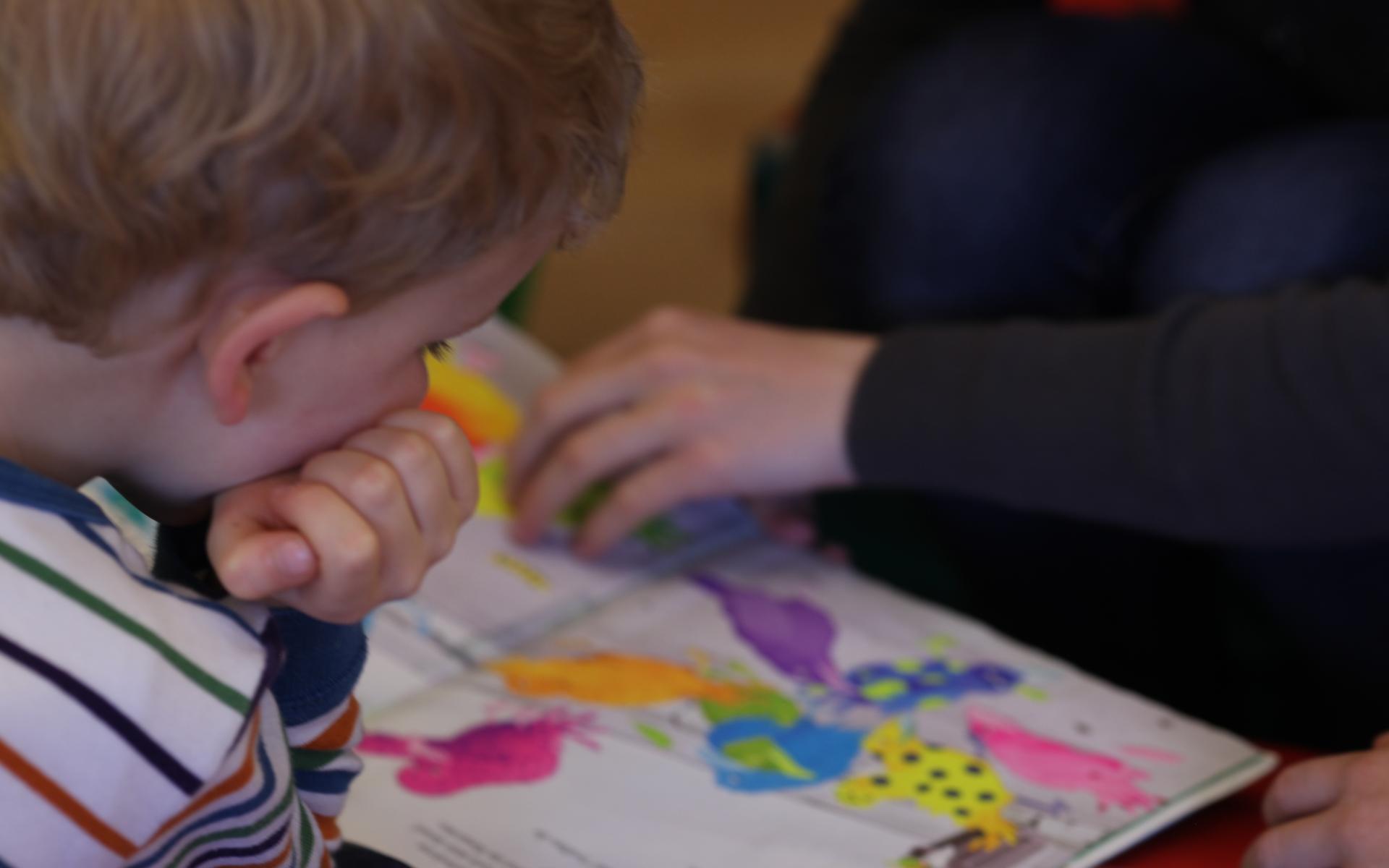 Symbolbild: Bub schaut auf ein Buch