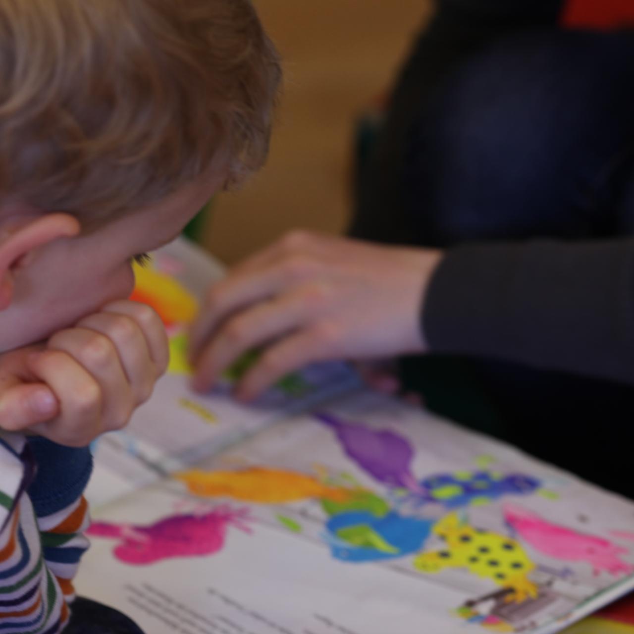 Symbolbild: Bub schaut auf ein Buch